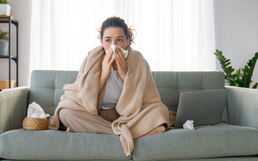 Woman on couch blowing nose due to poor indoor air quality