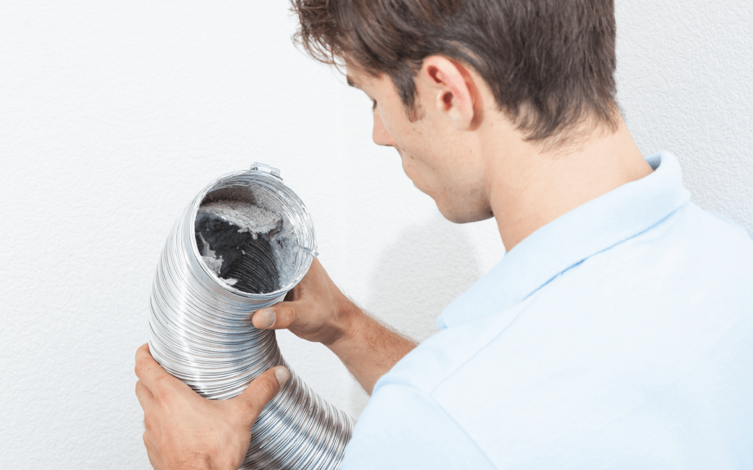 young man looking at a dirty dryer vent