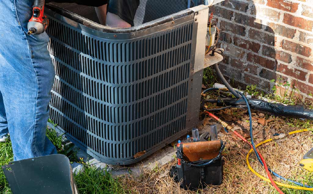 Repairman performing maintenance on air conditioner unit